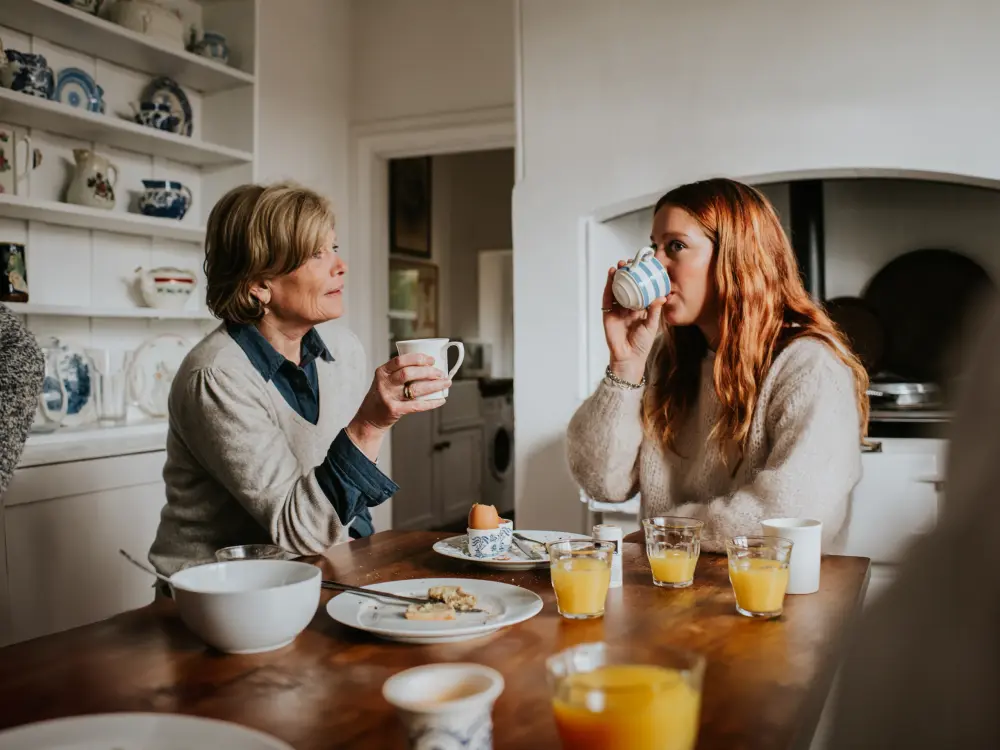 Twee vrouwen die koffie drinken en ontbijten in een gezellige keuken